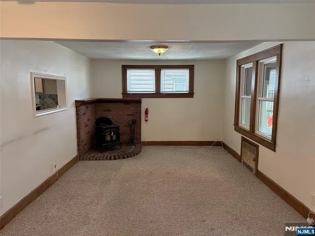 a view of an empty room with window and fireplace