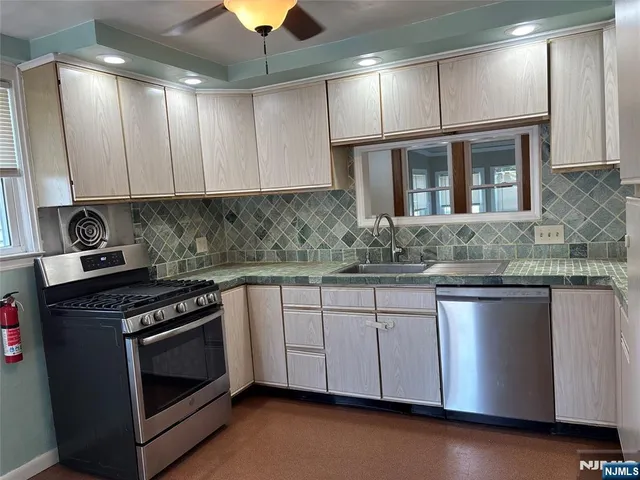 a kitchen with granite countertop a stove sink and cabinets