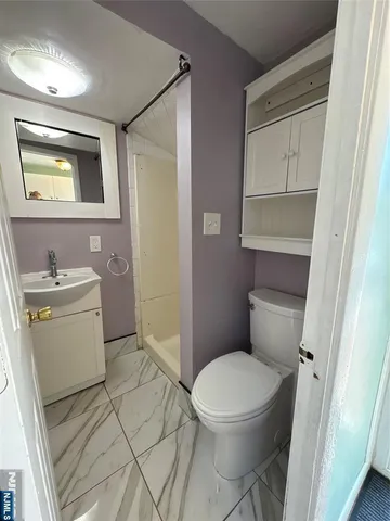 a white toilet sitting next to a bathroom sink and vanity