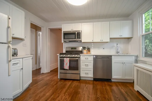a kitchen with white cabinets and stainless steel appliances