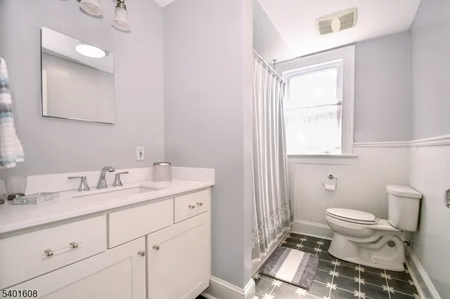a bathroom with a granite countertop sink a toilet and a mirror