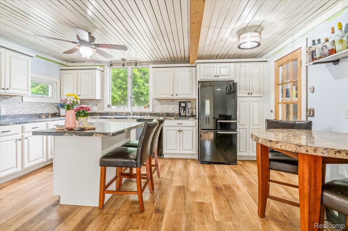 36940 Goddard Road Romulus, MI 48174 - Photo 11 of 31 Kitchen featuring a breakfast bar, freestanding refrigerator, ceiling fan, light wood finished floors, and a center island