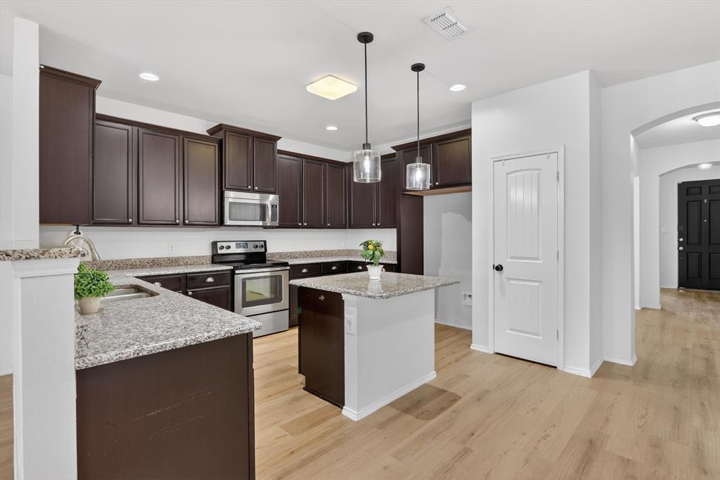 1627 Kawati Way Krum, TX 76249 - Photo 8 of 32 a kitchen with a refrigerator a sink and wooden floor