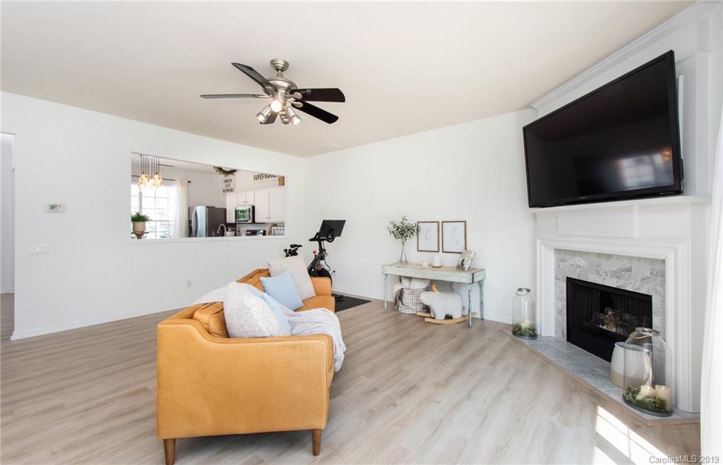 6864 Rothchild Drive Charlotte, NC 28270 - Photo 14 of 36 a living room with furniture a flat screen tv and kitchen view