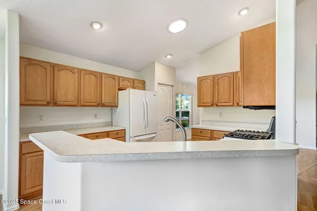 a kitchen with stainless steel appliances white cabinets and a stove top oven