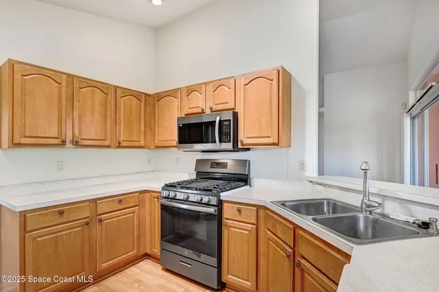 a kitchen with stainless steel appliances granite countertop a sink dishwasher stove and refrigerator