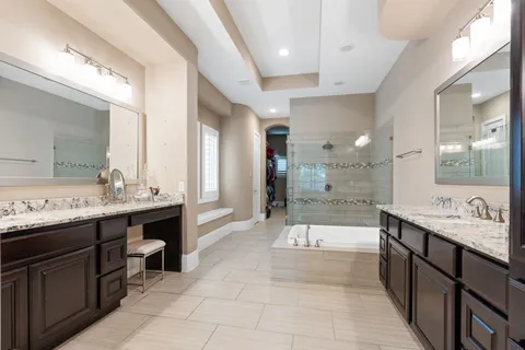 a large bathroom with a double vanity sink a large mirror and a shower