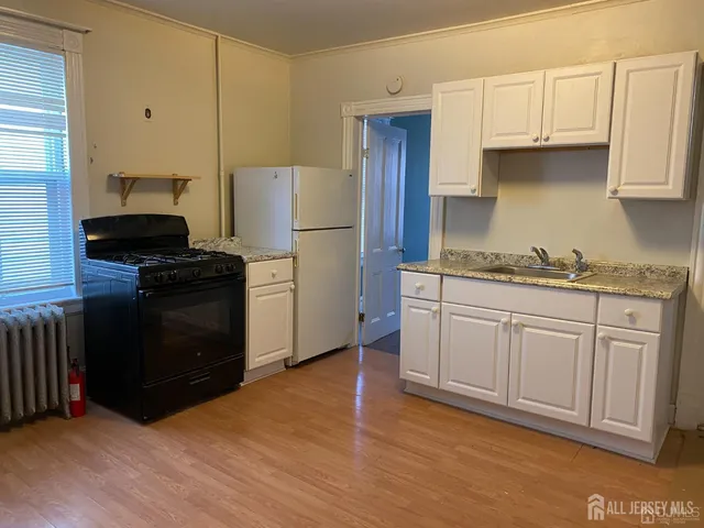 a kitchen with a sink a refrigerator and cabinets