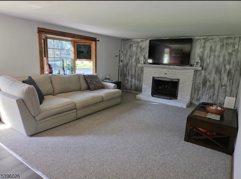 4435 Rudetown Road Hamburg, NJ 07419 - Photo 12 of 24 a living room with furniture a flat screen tv and a fireplace