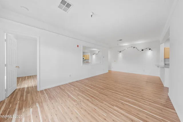 a view of empty room with wooden floor