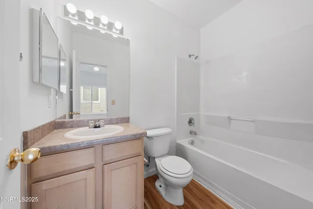 a bathroom with a granite countertop sink a toilet and bathtub