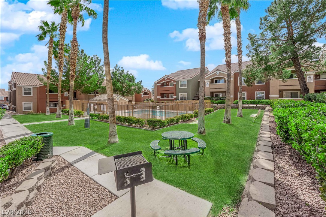 8101 West Flamingo Road, Unit 2030 Las Vegas, NV 89147 - Photo 6 of 27 A vibrant green lawn and inviting picnic area frame a refreshing community pool.