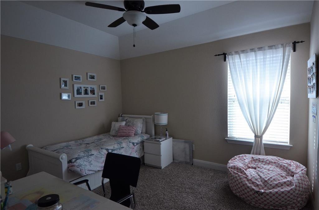 5629 Rio Chama Cove Austin, TX 78738 - Photo 21 of 34 A well-lit bedroom features plush carpeting and a modern ceiling fan, creating a comfortable personal retreat.