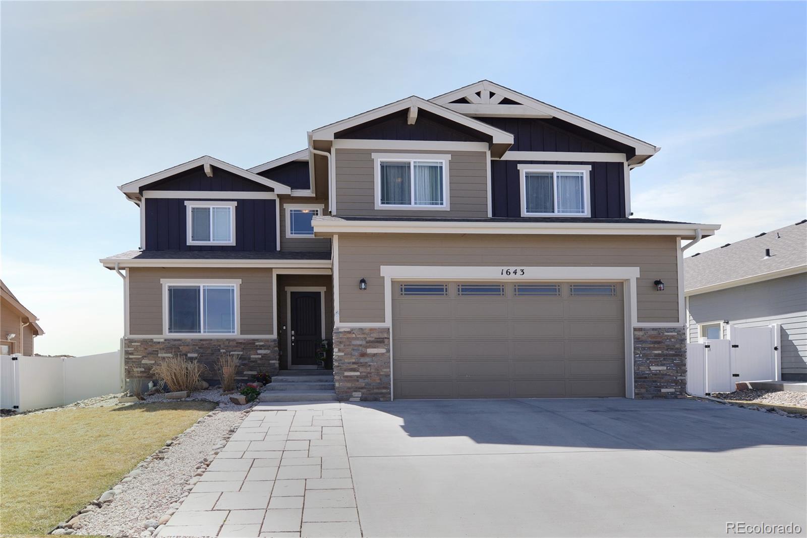 1643 Alpine Avenue Berthoud, CO 80513 - Photo 1 of 40 a front view of a house with a yard and garage
