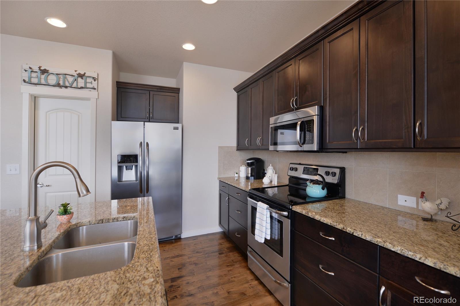 1643 Alpine Avenue Berthoud, CO 80513 - Photo 11 of 40 a kitchen with a refrigerator sink and cabinets