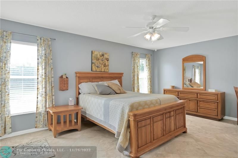 132 Drake Way Sebastian, FL 32958 - Photo 16 of 37 a spacious bedroom with a bed and a chandelier