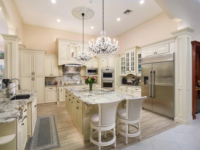 a dining room with stainless steel appliances kitchen island granite countertop a table and chairs