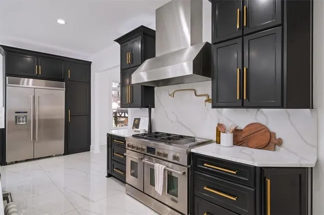 a view of kitchen with stainless steel appliances granite countertop white cabinets and a stove top oven