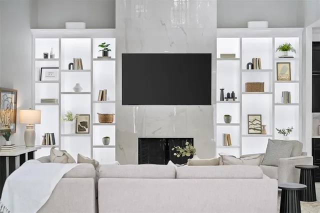 a living room with furniture a flat screen tv and a fireplace