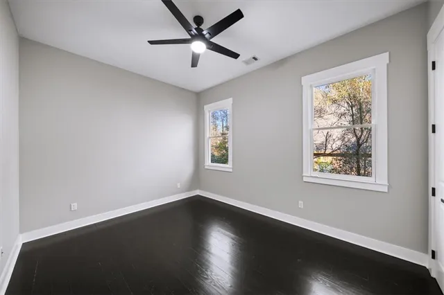 a view of a hallway with wooden floor and a ceiling fan