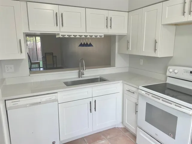 a kitchen with white cabinets and white appliances