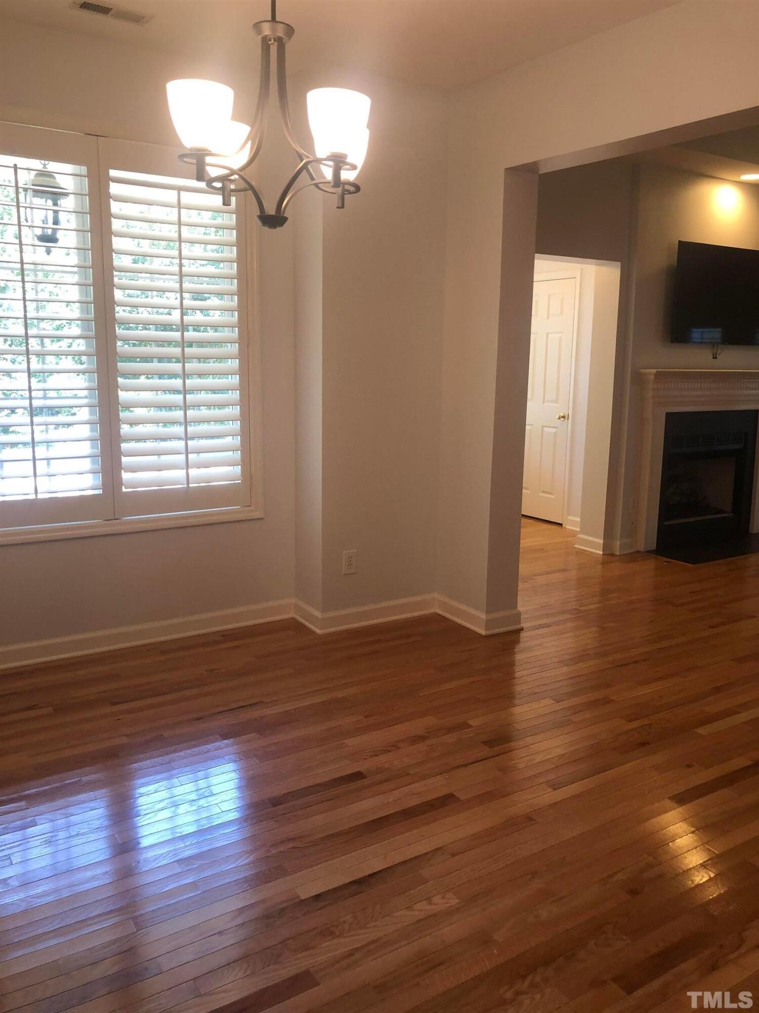 7601 Astoria Place Raleigh, NC 27612 - Photo 22 of 30 a view of empty room with wooden floor and fan