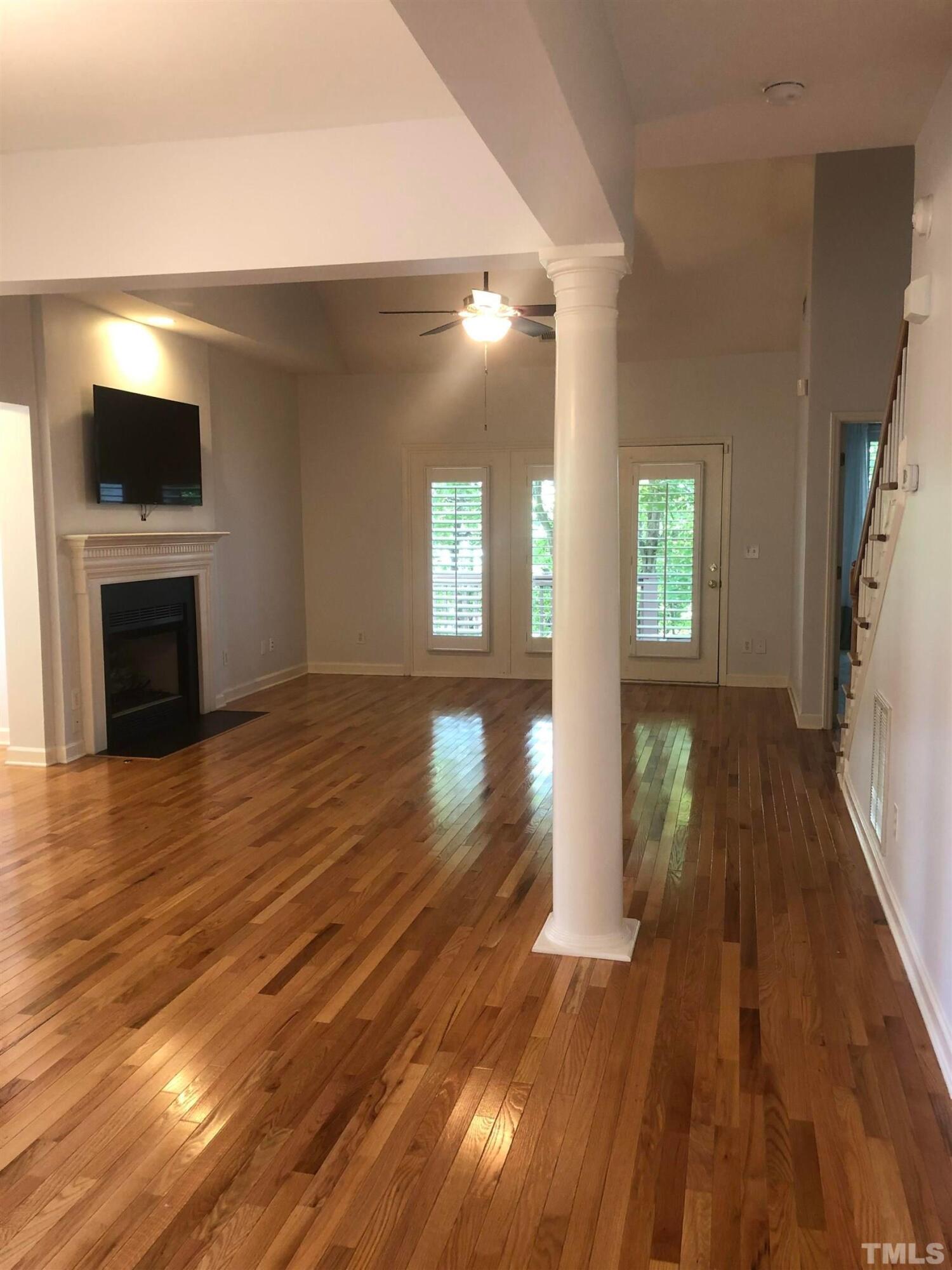 7601 Astoria Place Raleigh, NC 27612 - Photo 23 of 30 wooden floor in an empty room with a fireplace