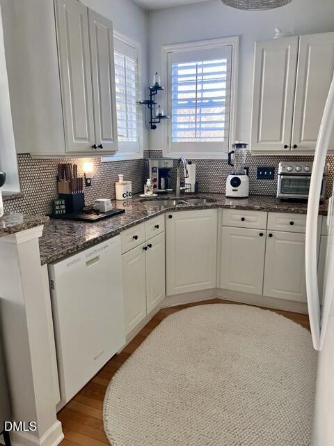 7601 Astoria Place Raleigh, NC 27612 - Photo 7 of 30 a kitchen with stainless steel appliances granite countertop a sink a stove a refrigerator a microwave oven with white cabinets