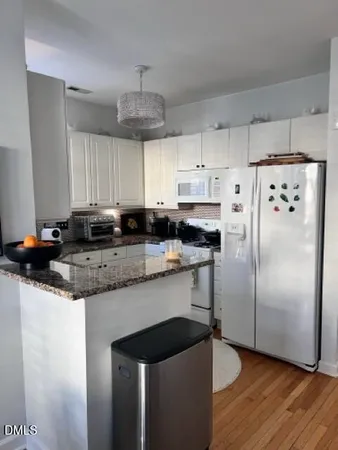 a kitchen with granite countertop a sink cabinets and stainless steel appliances