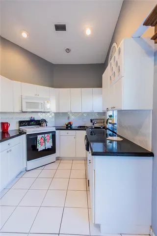 a kitchen with stainless steel appliances granite countertop a sink and a stove