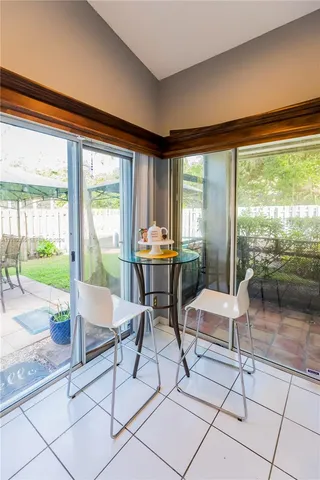 a dining room with furniture and a floor to ceiling window