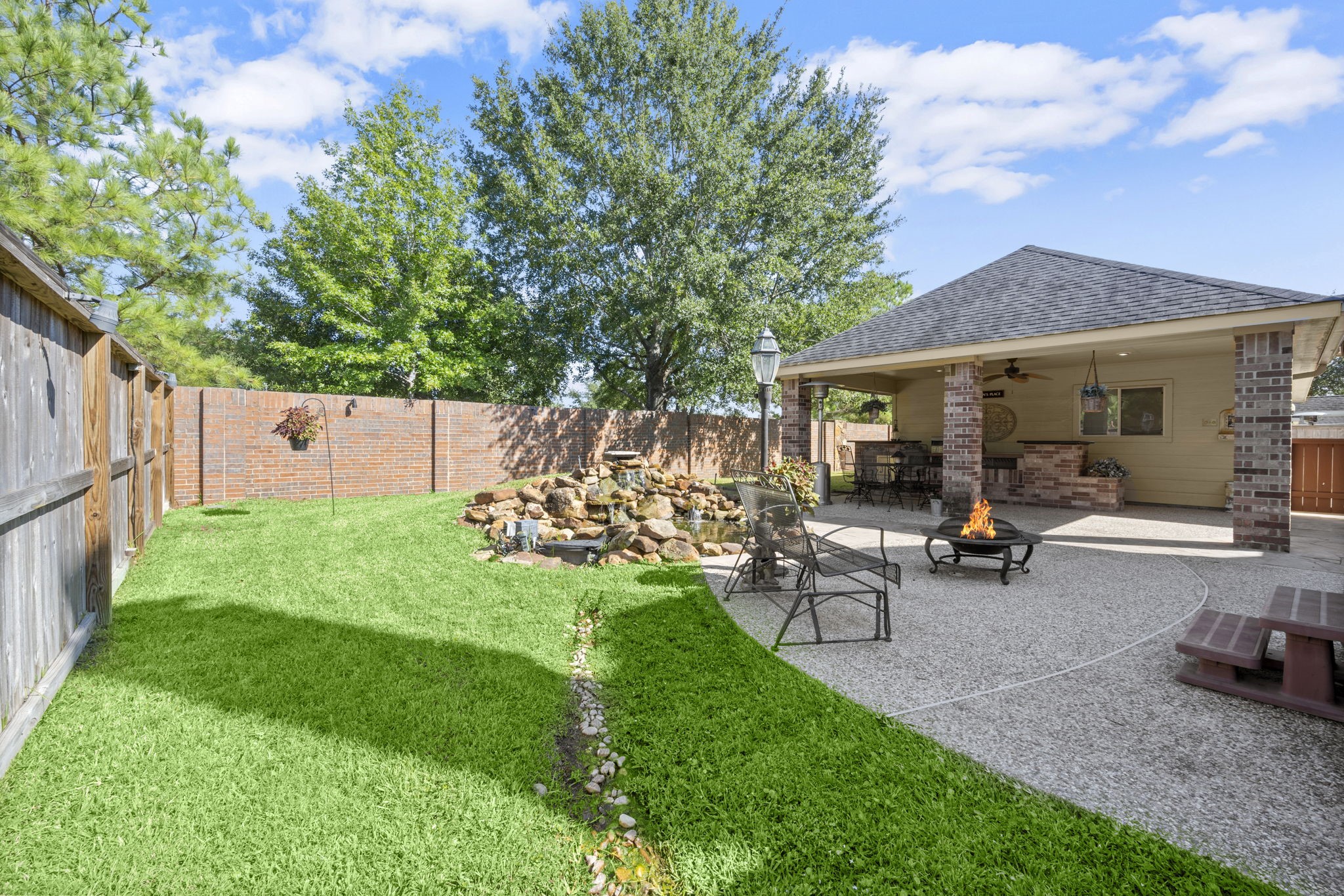 19902 Tidy Tips Lane Spring, TX 77379 - Photo 27 of 49 a view of a backyard with table and chairs potted plants and a large tree