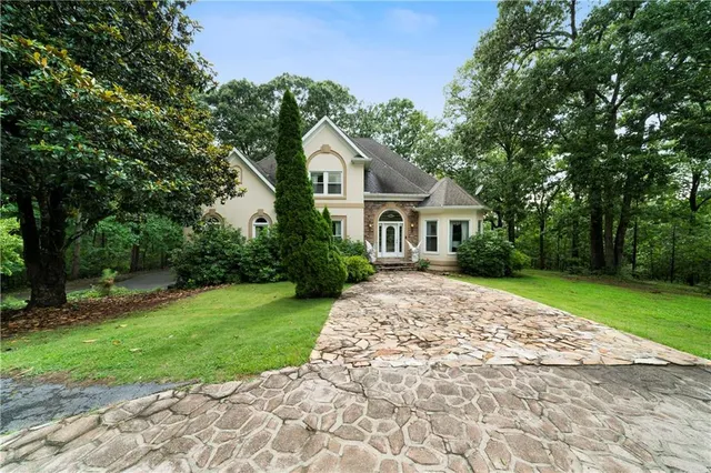 a house with green field in front of it