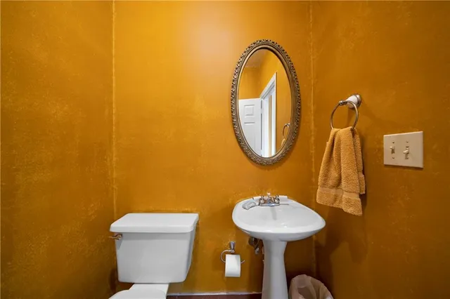 a bathroom with a sink mirror and toilet