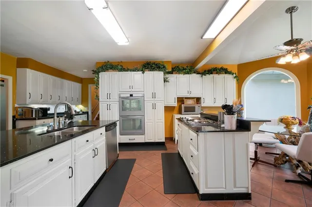 a kitchen with granite countertop a sink stove and cabinets
