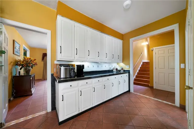 a kitchen with granite countertop white cabinets and stainless steel appliances