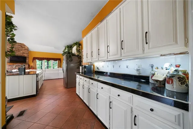 a kitchen with granite countertop white cabinets and stainless steel appliances