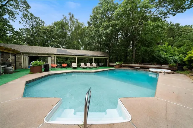 swimming pool view with a seating space and a garden