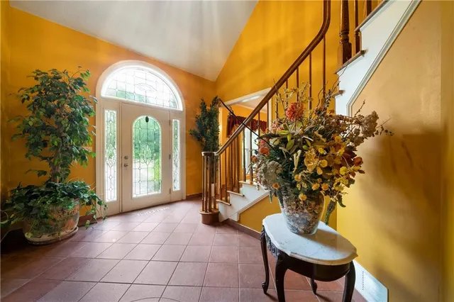 a view of hall way with furniture and a potted plant