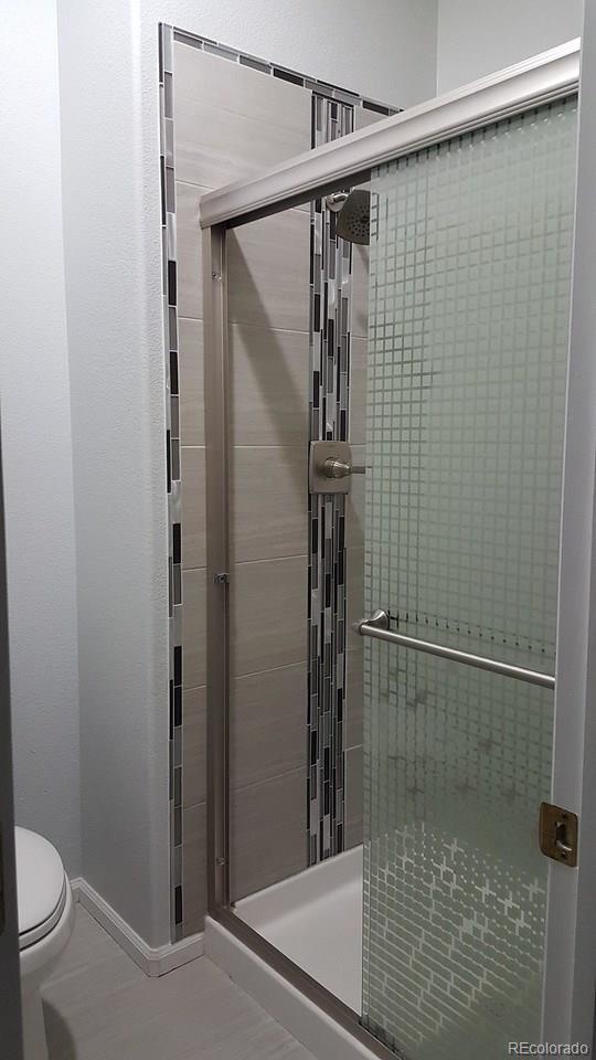 805 Nelson Park Drive Longmont, CO 80503 - Photo 21 of 33 a bathroom with a shower and a toilet
