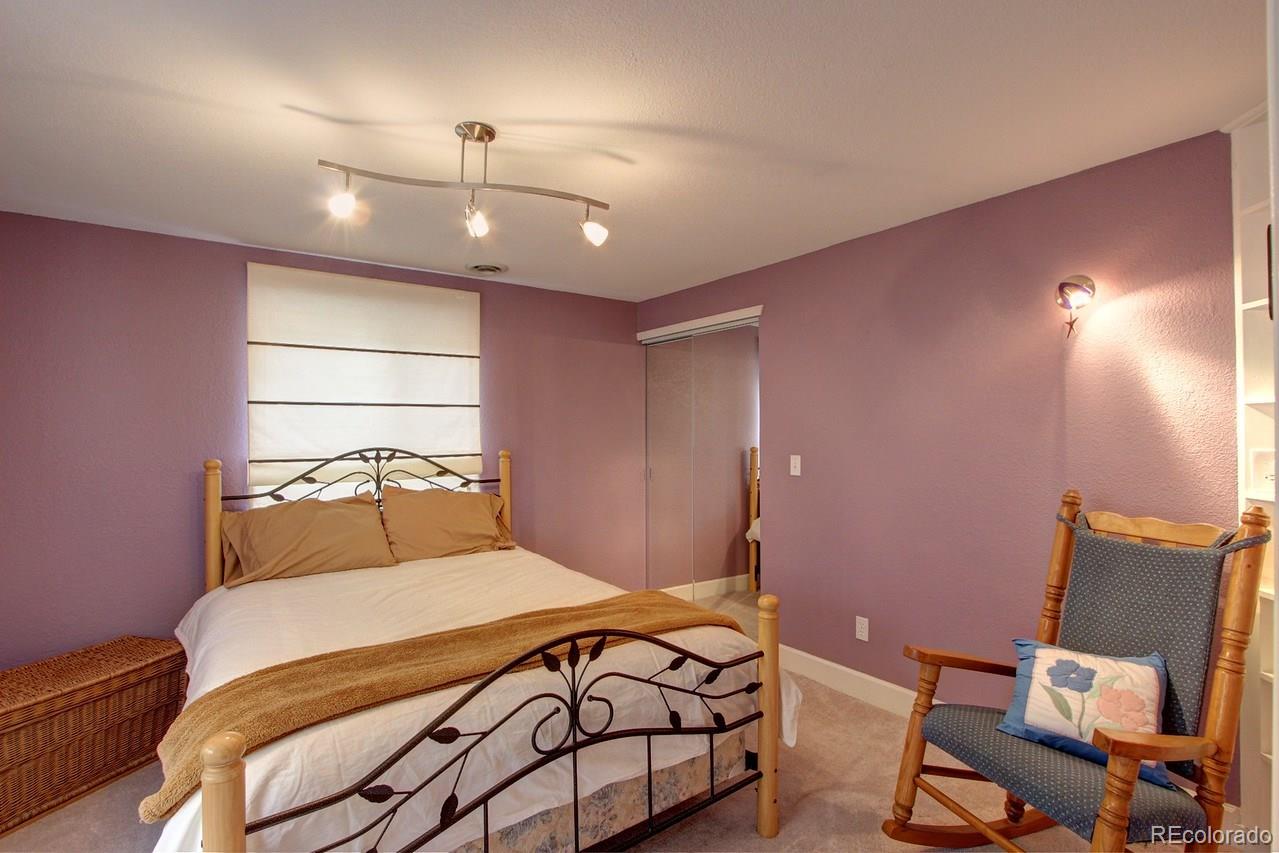 805 Nelson Park Drive Longmont, CO 80503 - Photo 23 of 33 a bedroom with a bed and a lamp with window