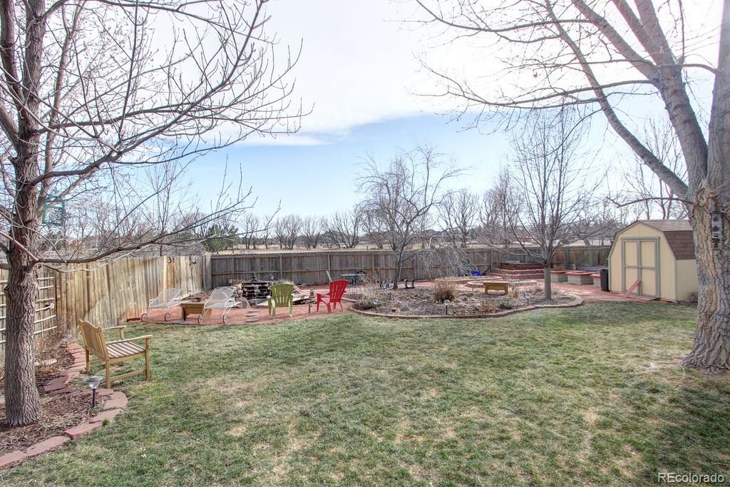 805 Nelson Park Drive Longmont, CO 80503 - Photo 32 of 33 a view of a backyard with table and chairs and a fire pit