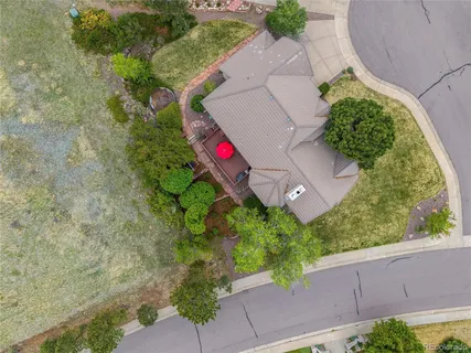 an aerial view of a house with a yard and a large tree