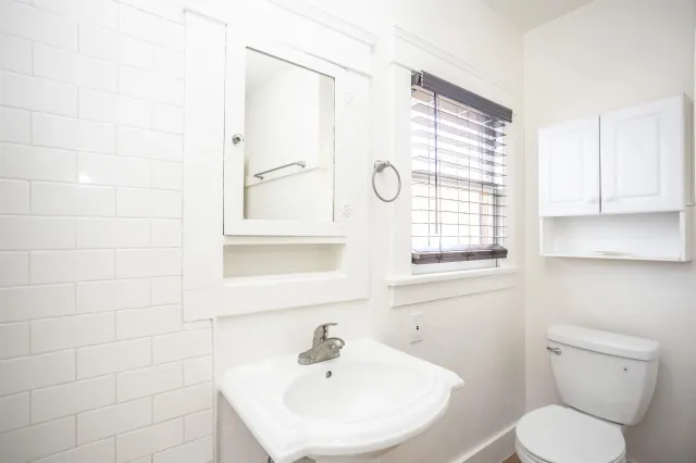 a bathroom with a sink a toilet and a window