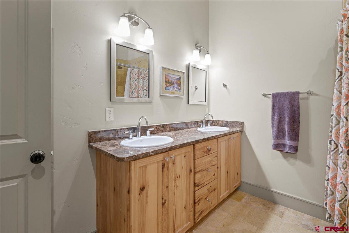 708 Main Street, Unit 3 Ouray, CO 81427 - Photo 18 of 28 a bathroom with a granite countertop sink and a mirror