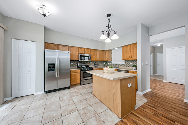 1079 Key Largo Drive Romeoville, IL 60446 - Photo 11 of 25 a kitchen with stainless steel appliances granite countertop a refrigerator and a sink