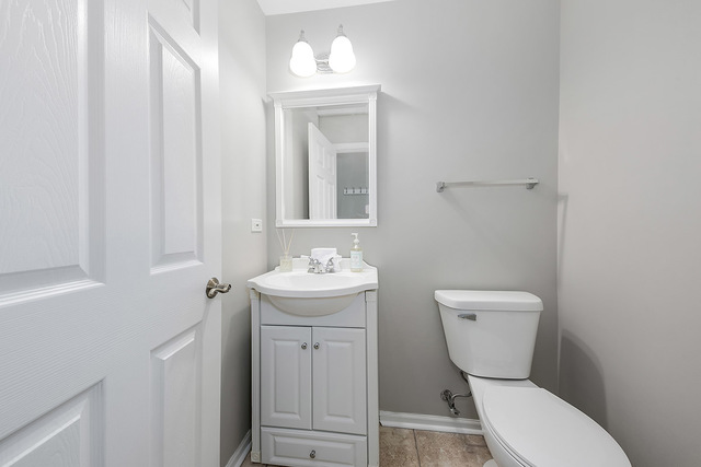 1079 Key Largo Drive Romeoville, IL 60446 - Photo 25 of 25 a bathroom with a toilet a sink and mirror