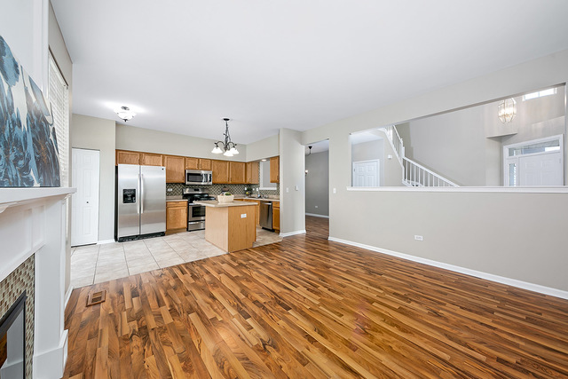 1079 Key Largo Drive Romeoville, IL 60446 - Photo 8 of 25 a large kitchen with kitchen island a sink stainless steel appliances and cabinets