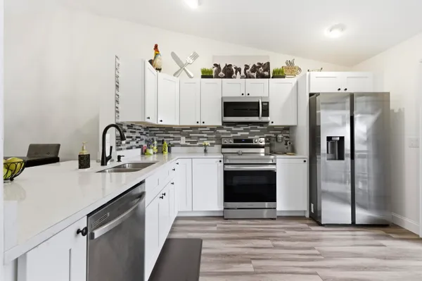 a kitchen with stainless steel appliances a stove microwave and a refrigerator