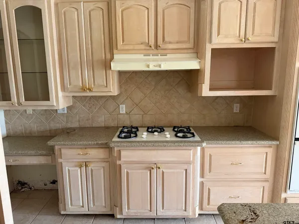 a kitchen with granite countertop white cabinets and a stove